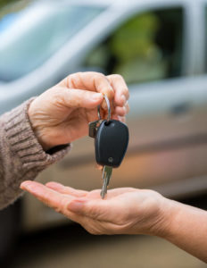 Woman giving keys from a car to another woman